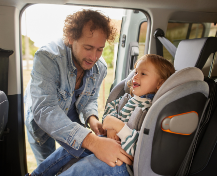 dad buckling kid in car seat
