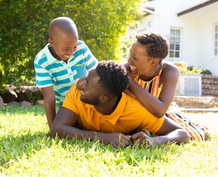 happy family laughing and lying in grass