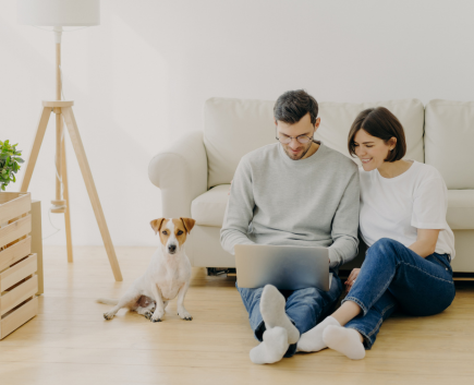 Couple looking at computer with dog