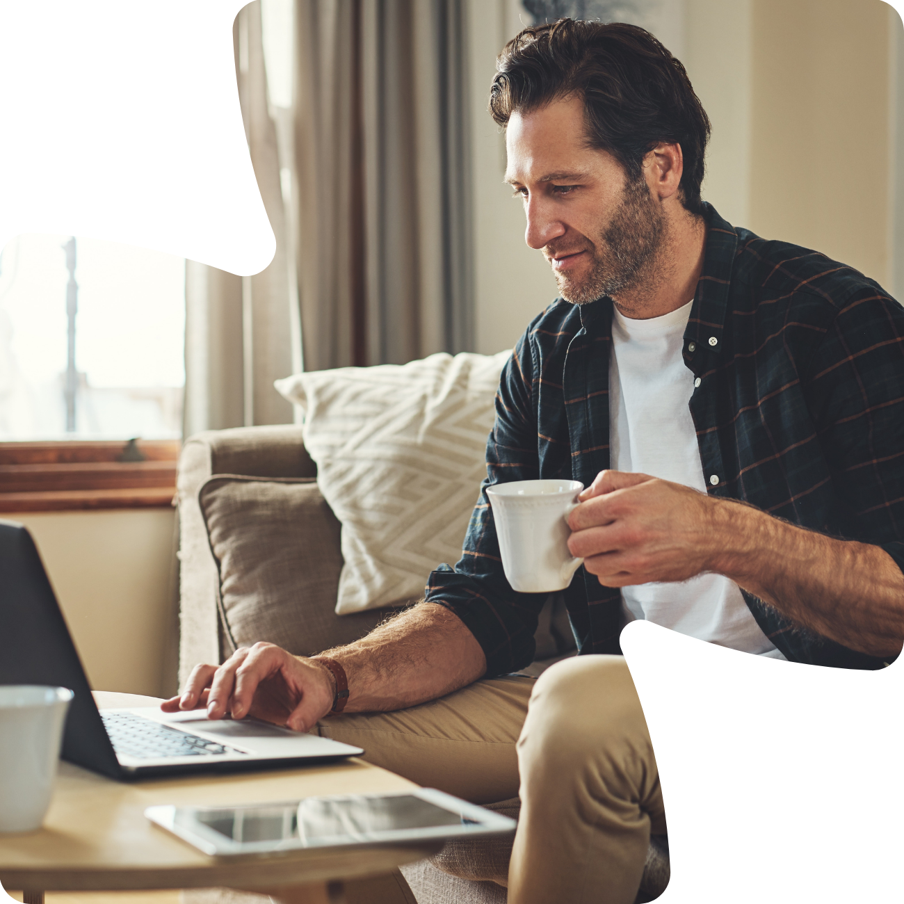 man on laptopn holding coffee mug