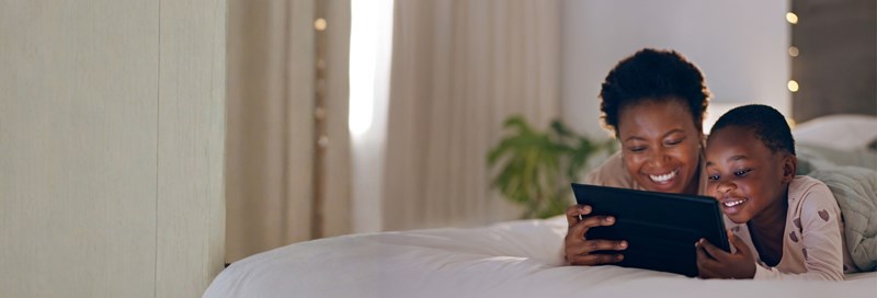 mom and child laying down with laptop