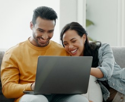 couple smiling at laptop