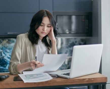 tired woman looking at bills